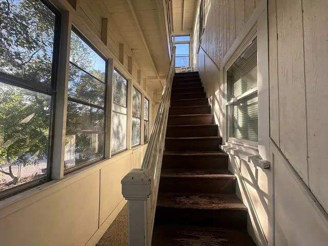 a view of staircase with wooden floor and white walls