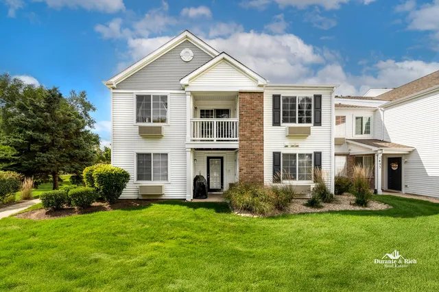 a front view of a house with a garden and plants