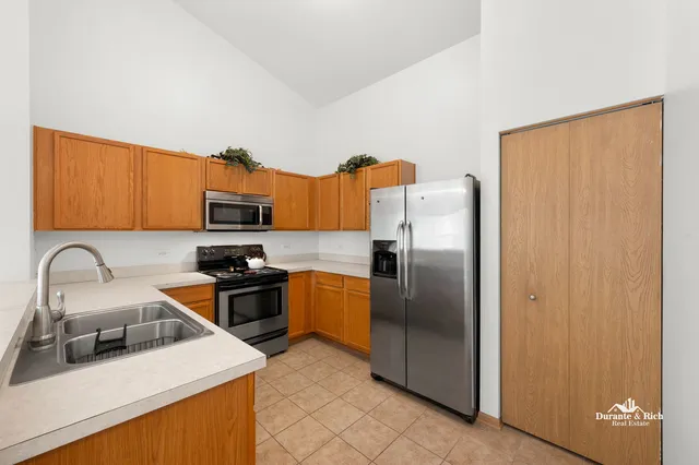 a kitchen with stainless steel appliances granite countertop a refrigerator a sink a stove top oven and a dishwasher