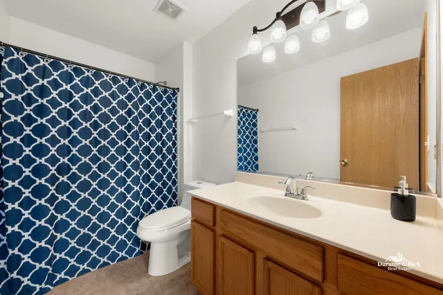 a bathroom with a sink a toilet a mirror and shower