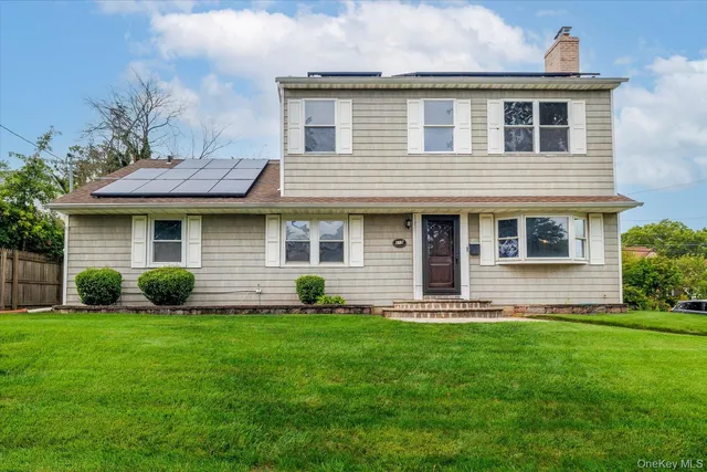 a front view of a house with a yard and green space