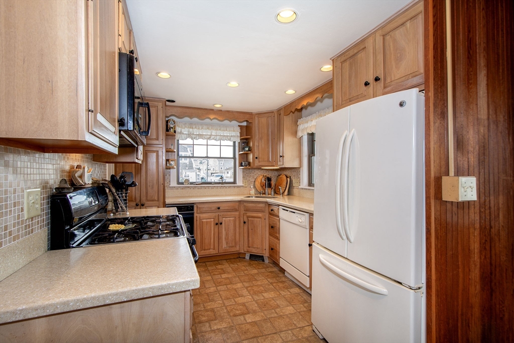 42 Lighthouse Road Scituate, MA 02066 - Photo 11 of 27 a kitchen with granite countertop a refrigerator a sink a stove and cabinets