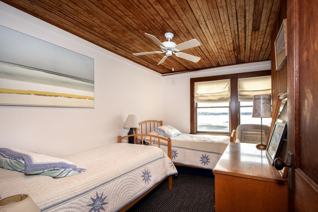 42 Lighthouse Road Scituate, MA 02066 - Photo 21 of 27 a bedroom with a bed and a chandelier