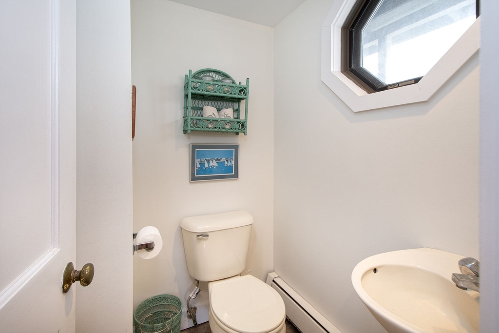 42 Lighthouse Road Scituate, MA 02066 - Photo 27 of 27 a white toilet sitting next to a bathroom sink and a mirror
