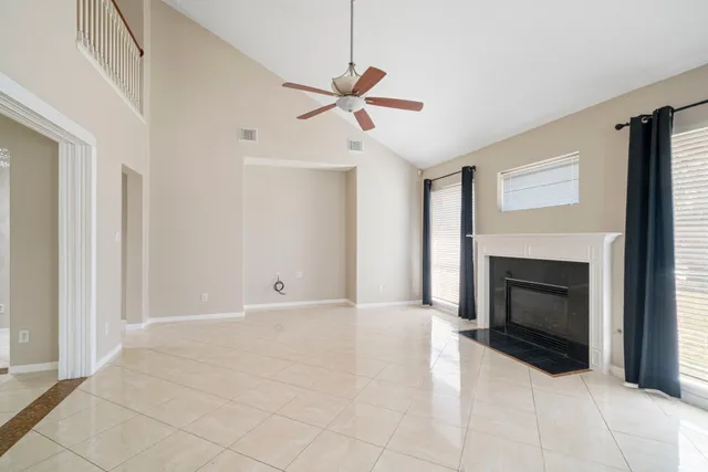 a view of empty room with fireplace and fan