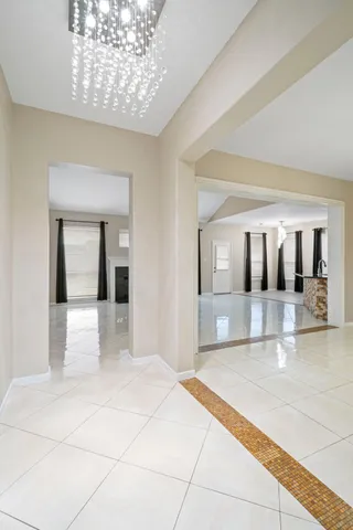 a view of spacious bedroom with a large bed and chandelier