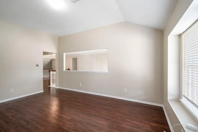 a view of a livingroom with wooden floor and window