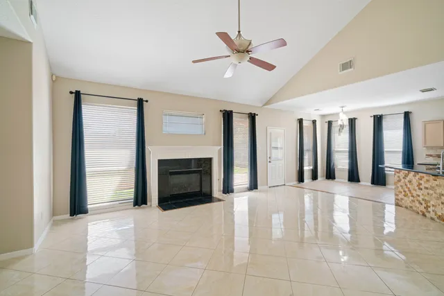 a view of an empty room with a fireplace and a window