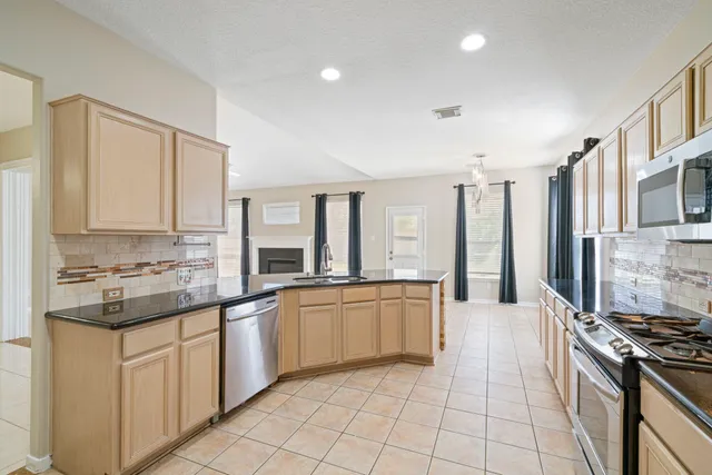 a kitchen with stainless steel appliances granite countertop a stove and a sink