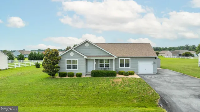 a view of house in front of a big yard with potted plants