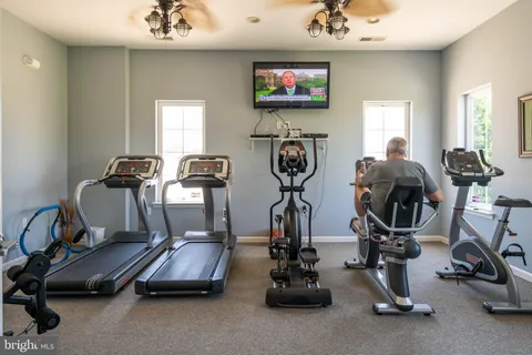 an aerial view of a tennis ground and a cars park side of a road