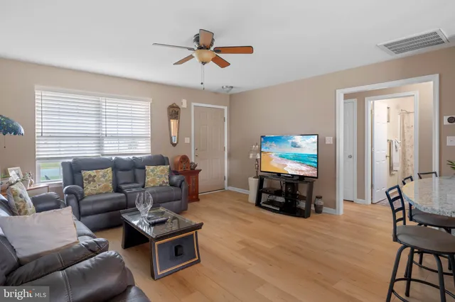 a living room with furniture and a flat screen tv with wooden floor