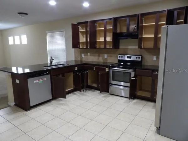a kitchen with stainless steel appliances granite countertop a stove a sink and a refrigerator