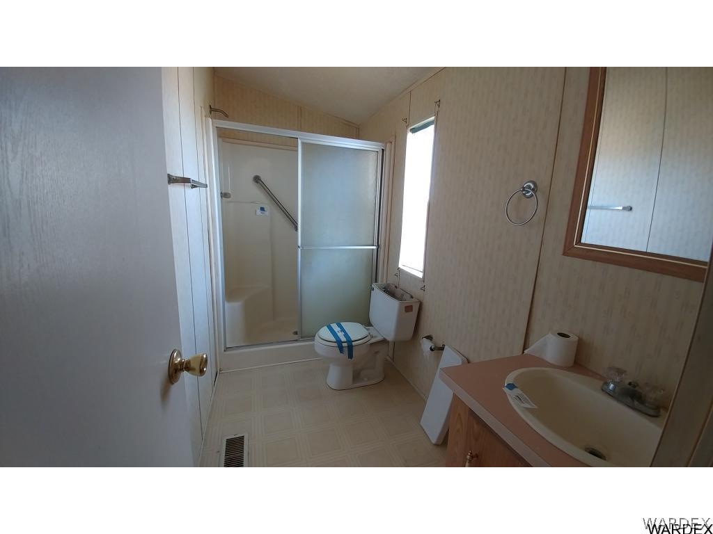 4905 Teddy Roosevelt Road Golden Valley, AZ 86413 - Photo 21 of 29 a bathroom with a sink mirror and toilet