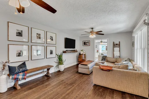 a living room with furniture flat screen tv and a window