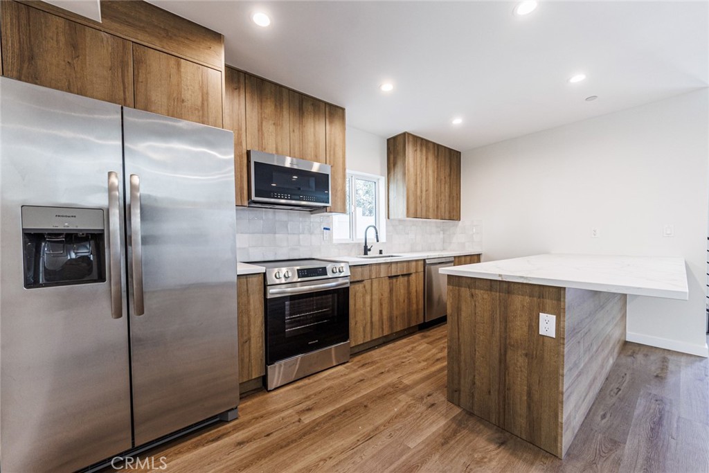 1855 Crenshaw Boulevard Los Angeles, CA 90019 - Photo 8 of 22 a kitchen with stainless steel appliances granite countertop a refrigerator a sink a stove a microwave a sink and a refrigerator