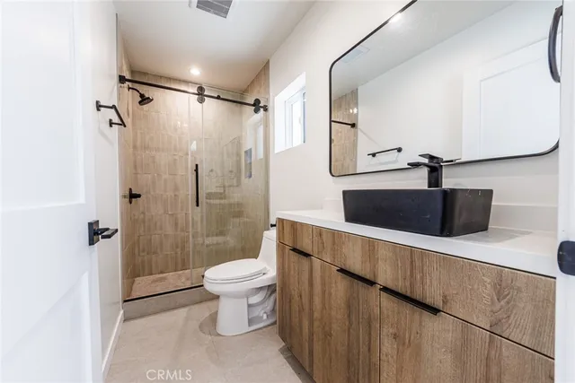a bathroom with a sink a toilet and shower
