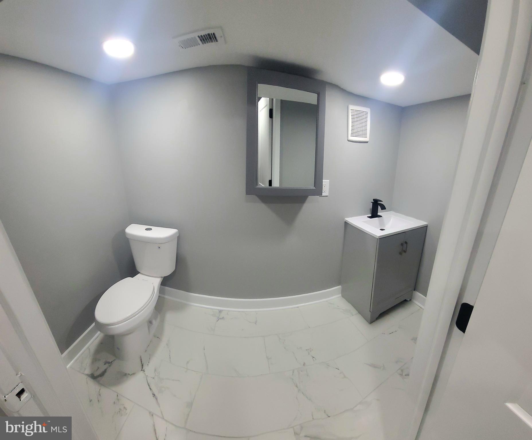 4542 Sansom Street Philadelphia, PA 19139 - Photo 30 of 36 a bathroom with a toilet sink and mirror