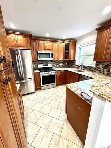 a kitchen with stainless steel appliances granite countertop a stove a sink and a refrigerator