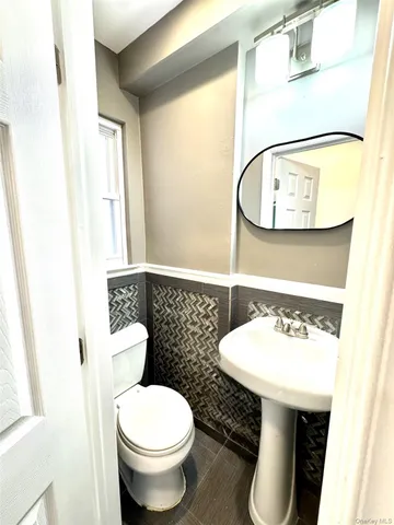 a bathroom with a toilet a sink and a mirror