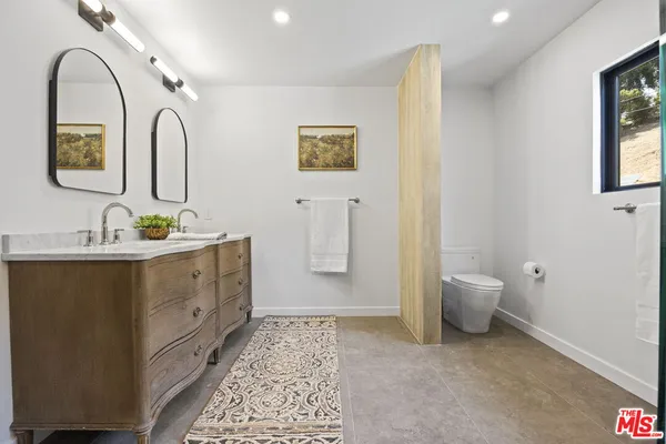 a bathroom with a granite countertop sink a mirror and shower