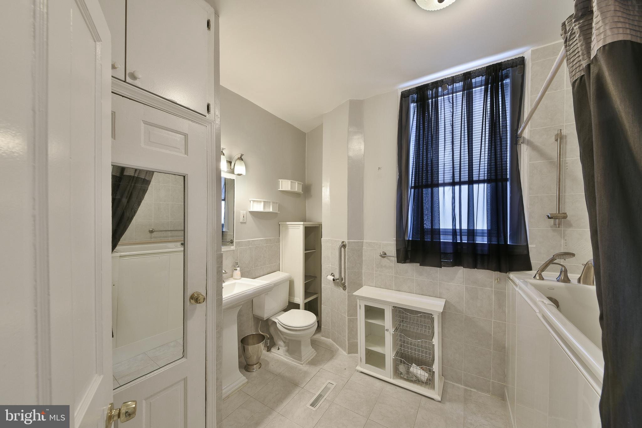 5331 Race Street Philadelphia, PA 19139 - Photo 11 of 21 a bathroom with a bathtub shower sink mirror and toilet