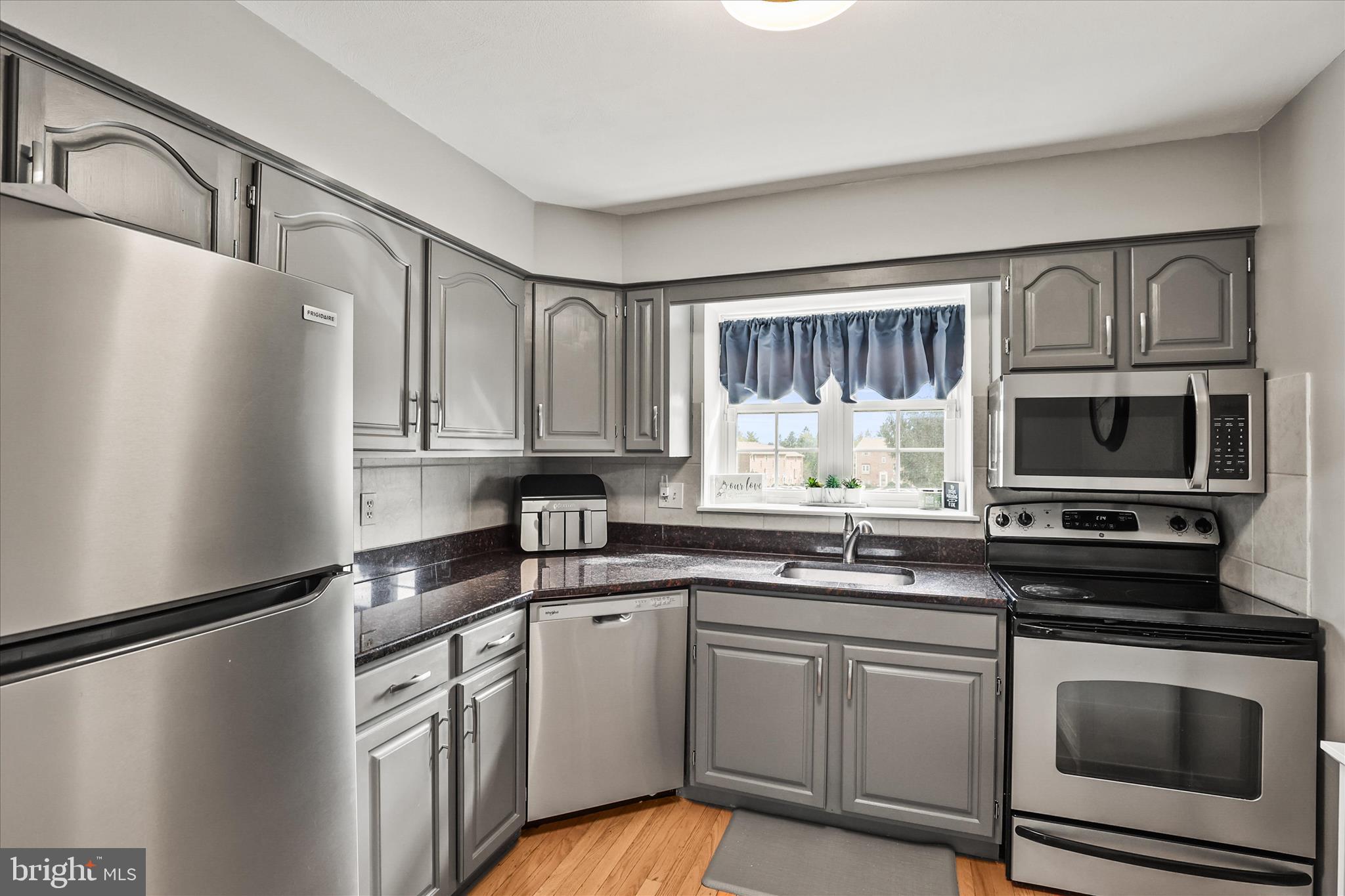 451 Weldon Drive, Unit 451 York, PA 17404 - Photo 11 of 38 a kitchen with stainless steel appliances granite countertop a refrigerator sink stove microwave and cabinets