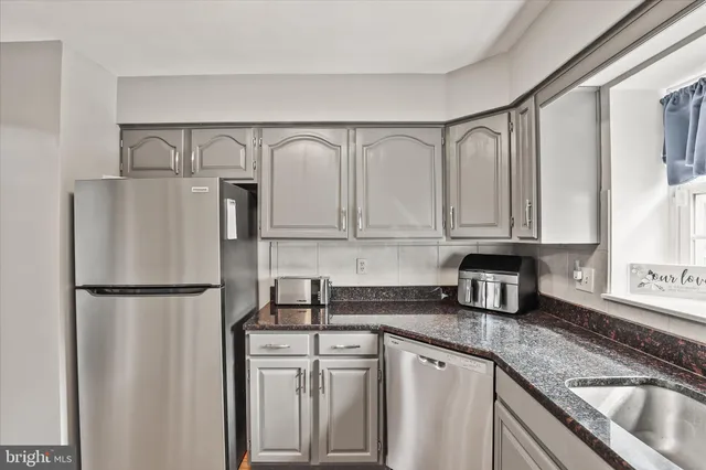 a kitchen with stainless steel appliances granite countertop a refrigerator sink and cabinets