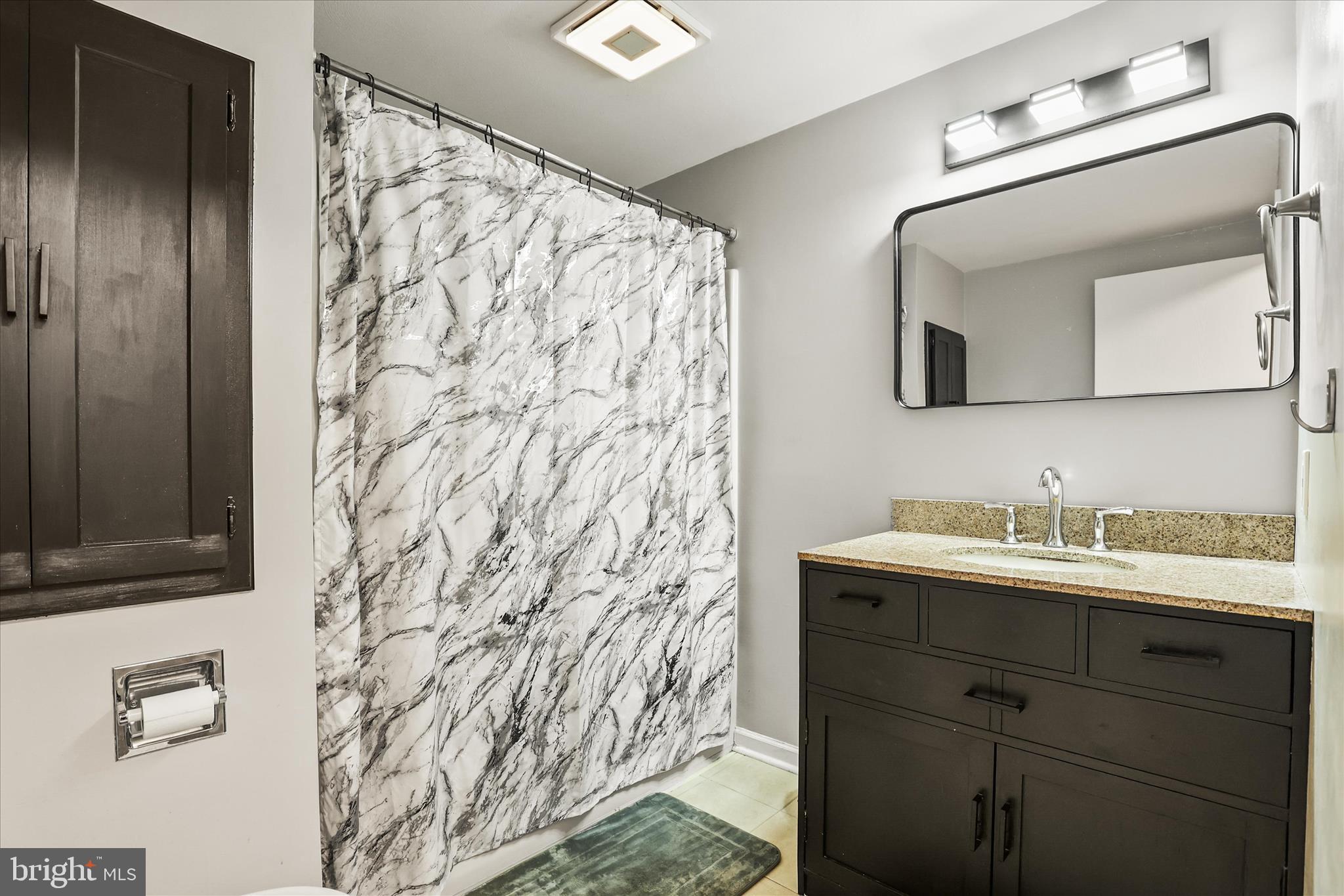 451 Weldon Drive, Unit 451 York, PA 17404 - Photo 17 of 38 a bathroom with a granite countertop sink a mirror and shower curtain