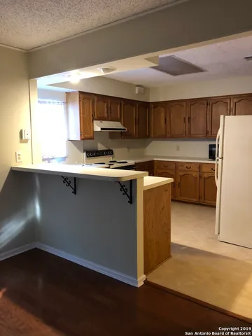 a kitchen with a sink a stove a refrigerator and a window