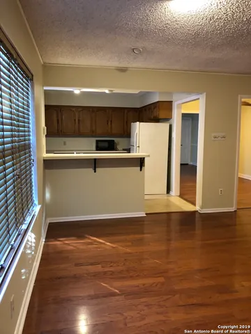 a view of a kitchen with wooden floor and electronic appliances