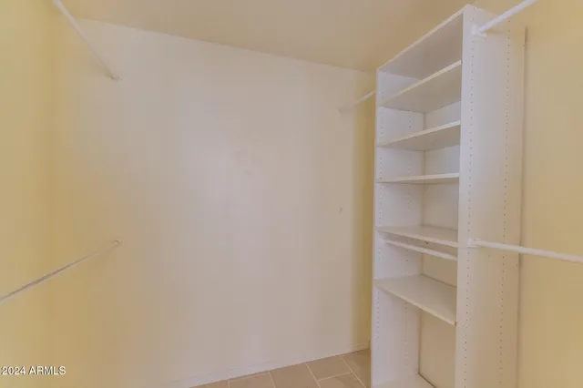 an empty room with a window and ceiling fan