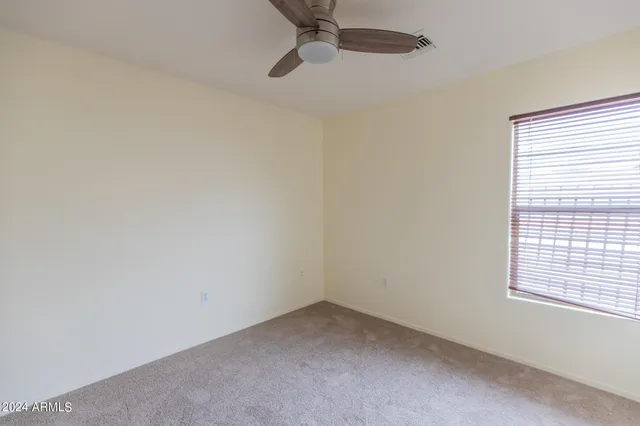 a view of an empty room and chandelier fan