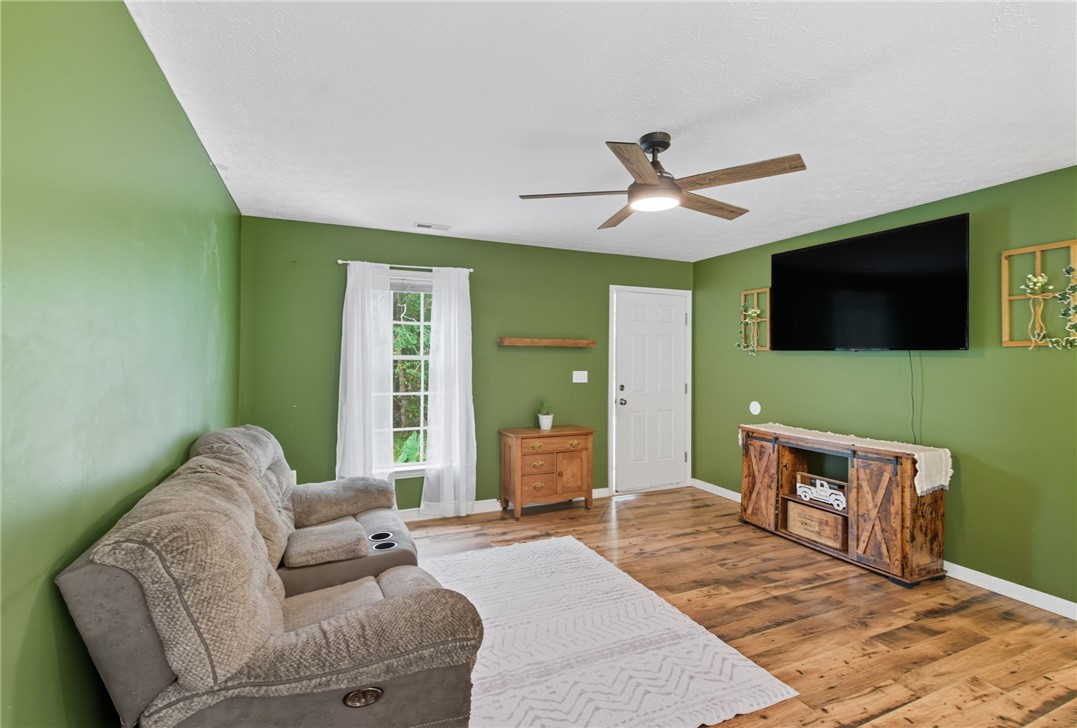 878 Salvia Road Newtown, VA 23126 - Photo 8 of 33 Living area with wood finished floors, ceiling fan, and a textured ceiling