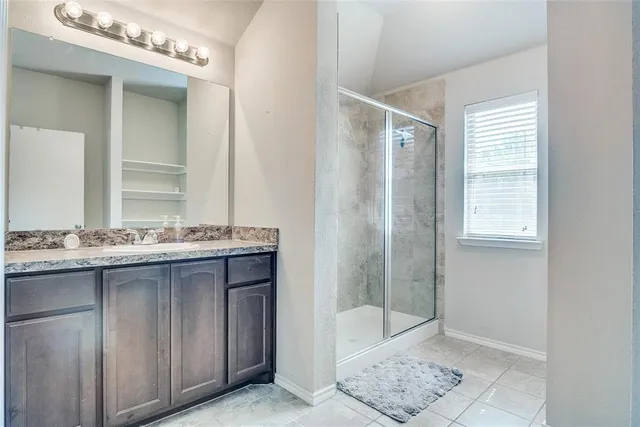 a bathroom with a granite countertop sink a mirror and a bathtub