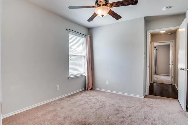 an empty room with fan and windows