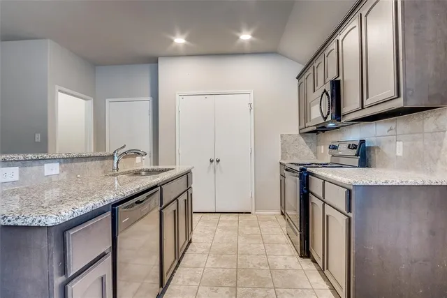 a kitchen with stainless steel appliances granite countertop a sink stove and cabinets