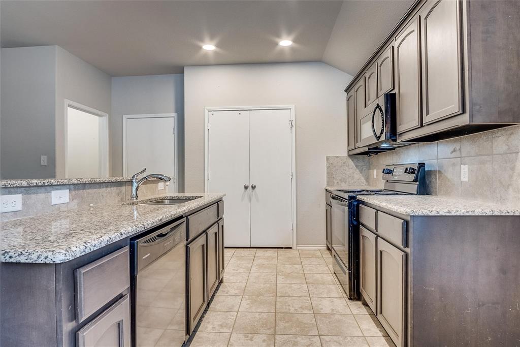 227 Walnut Bend Road Springtown, TX 76082 - Photo 7 of 31 a kitchen with stainless steel appliances granite countertop a sink stove and cabinets