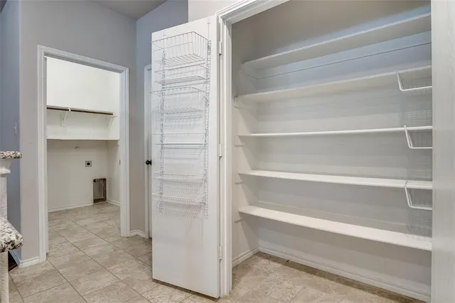 a view of walk in closet with empty racks