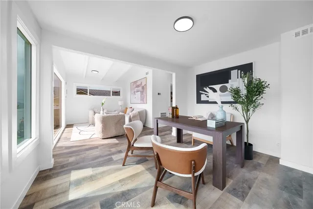 a dining room with furniture potted plants and wooden floor