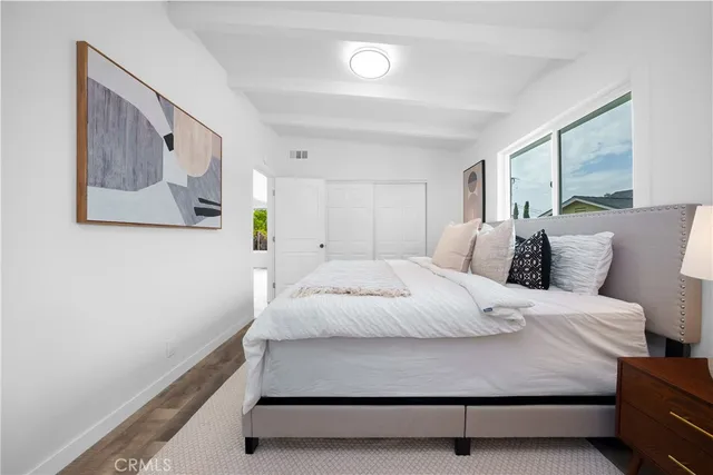 a large bed sitting in a bedroom next to a window