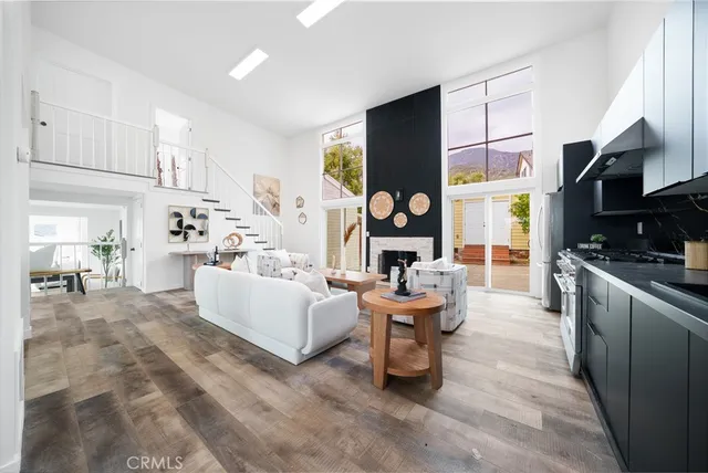 a living room with furniture a fireplace and a kitchen view