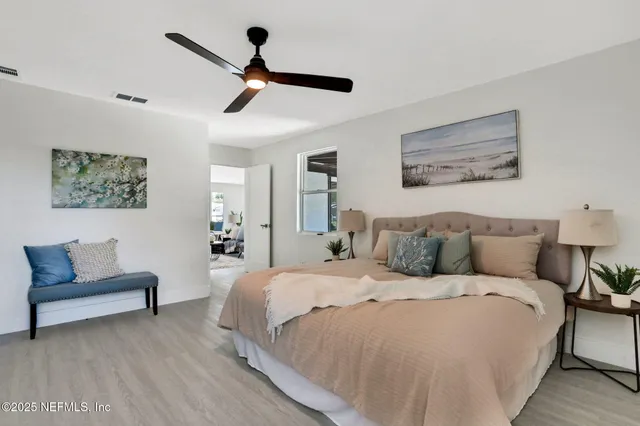 a bedroom with a bed a couch and a potted plant