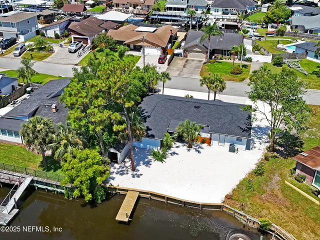 an aerial view of a house with a yard and seating area