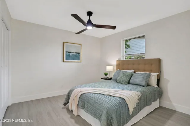 a bedroom with a bed and painting on the wall