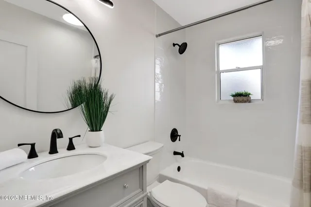 a bathroom with a sink toilet a tub and mirror