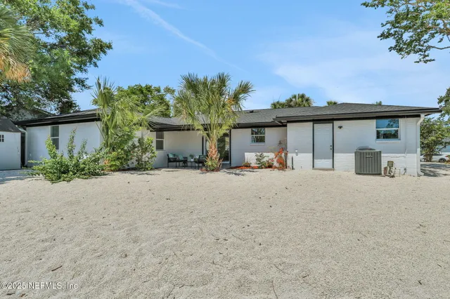 front view of a house with a yard and a trees