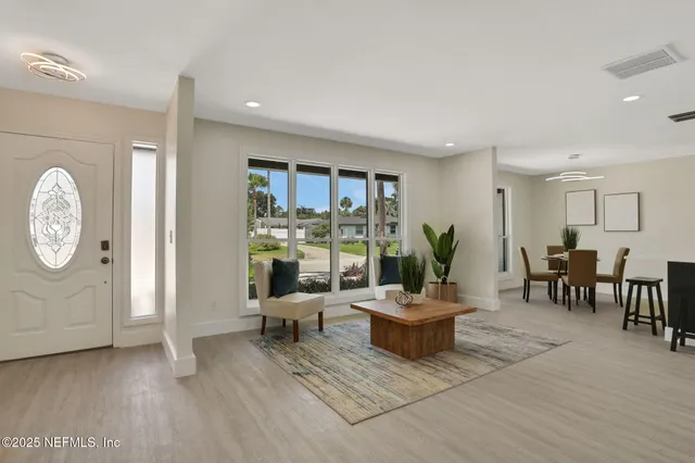 a living room with furniture a lamp and a large window