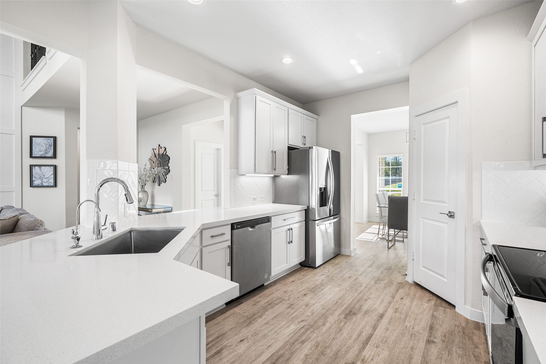 11731 Oakwood Rnch Drive Willis, TX 77378 - Photo 15 of 43 a kitchen with stainless steel appliances kitchen island granite countertop a refrigerator a sink a stove and white cabinets with wooden floor