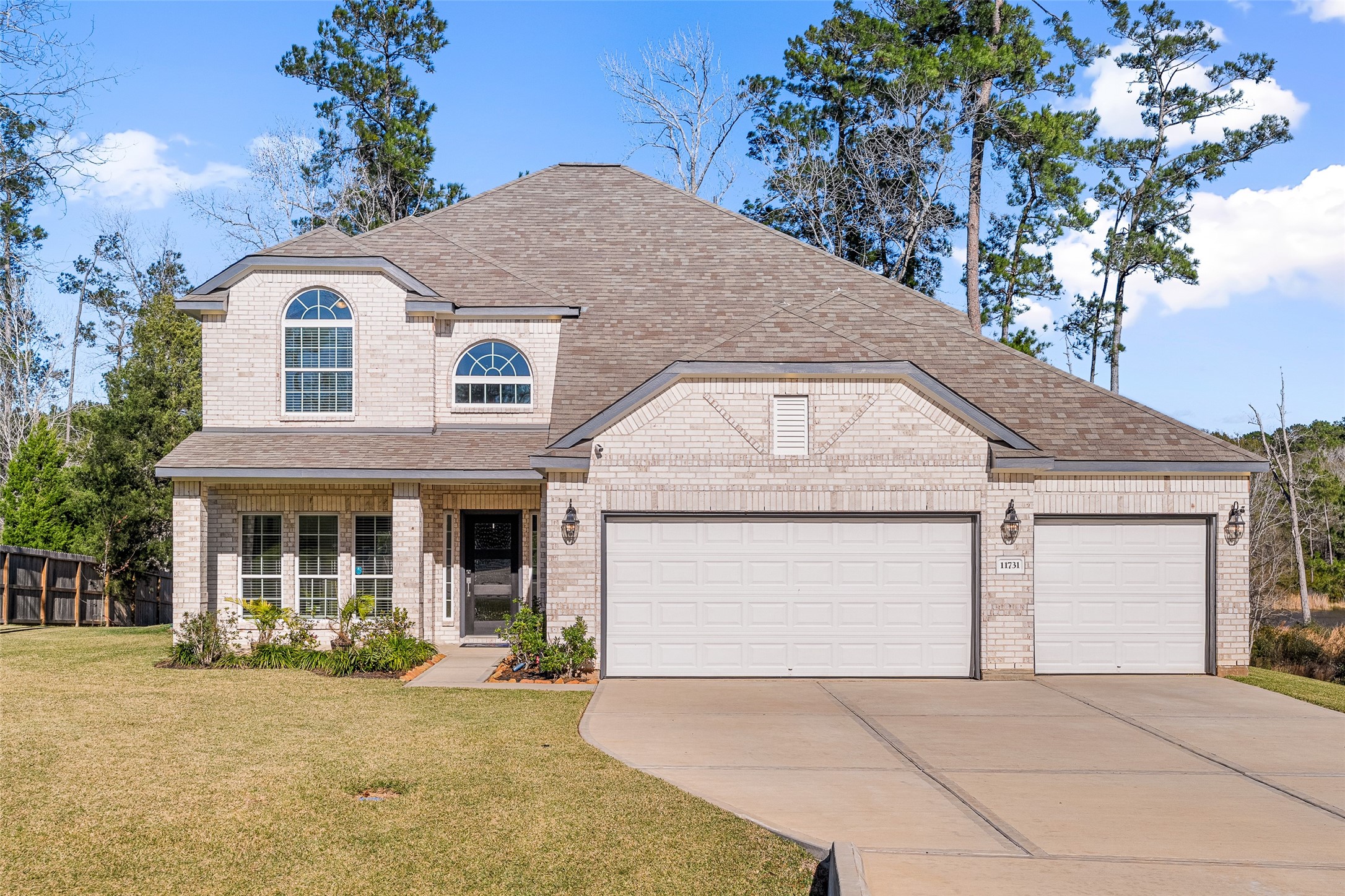 11731 Oakwood Rnch Drive Willis, TX 77378 - Photo 3 of 43 a front view of a house with a yard and garage